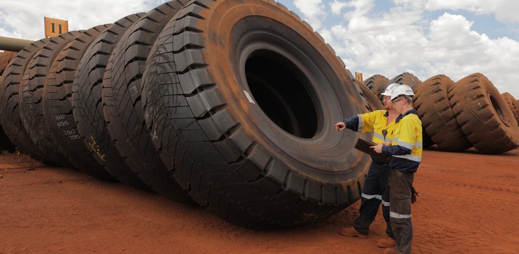 Otraco workers inspecting large mining tyres